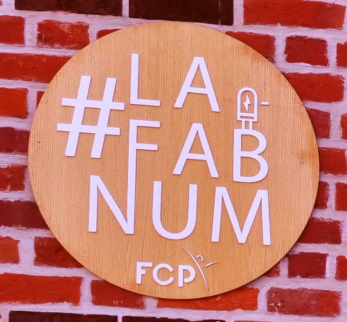 Panneau en bois sur la façade de la FabNum